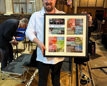 Lee Dunleavy is presented with a collage to remind him of his four years as MD of the choir